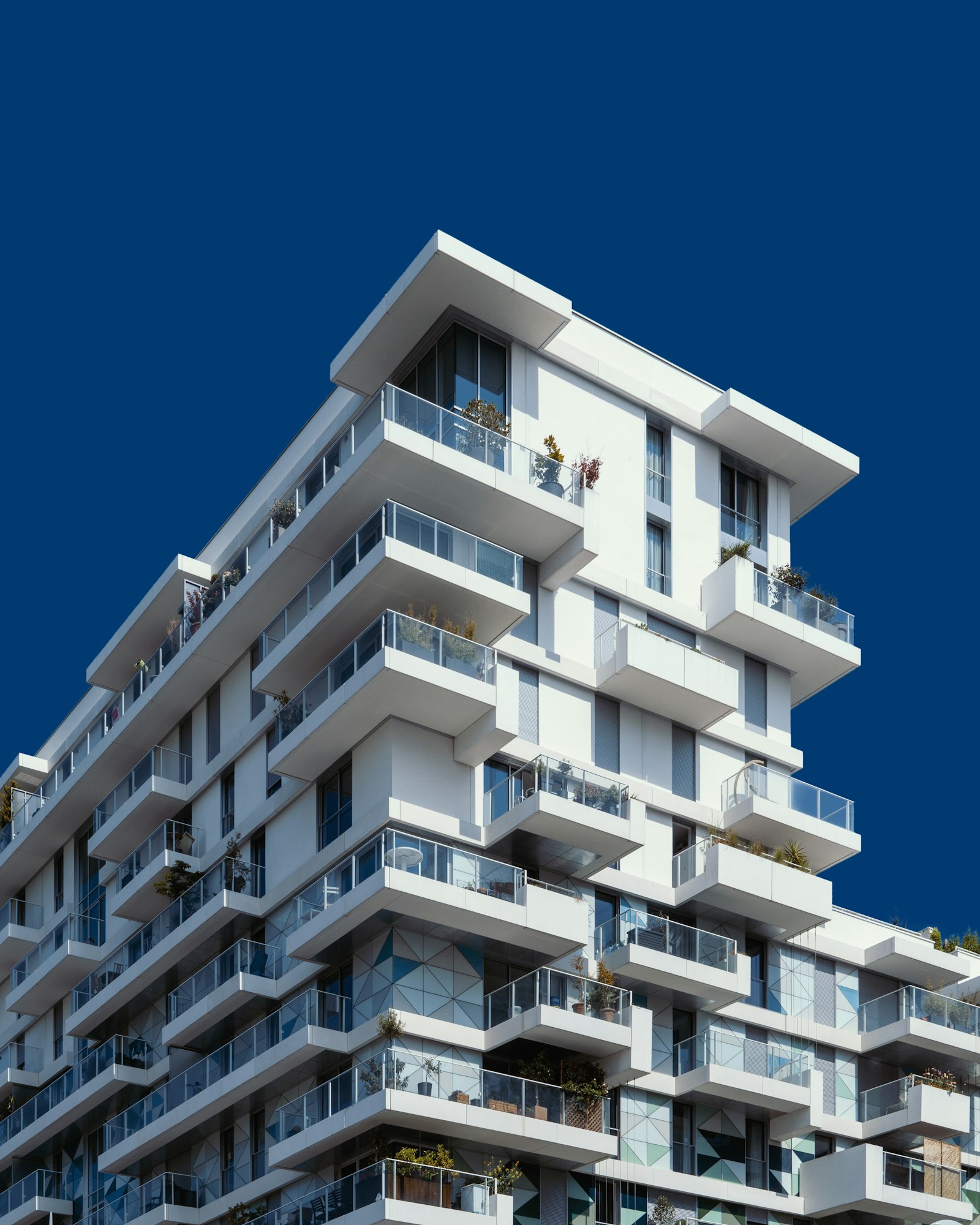 Modern luxury apartment building facade against a deep blue sky